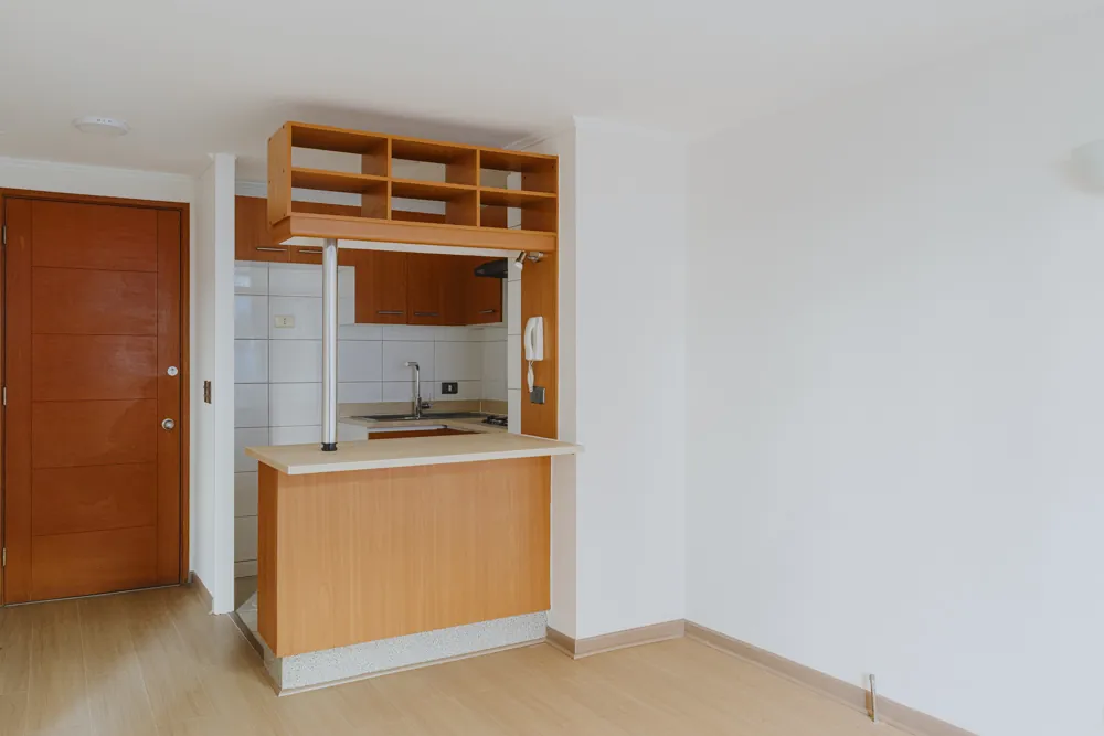 Cocina con barra y puerta de acceso, departamento Amunátegui 573