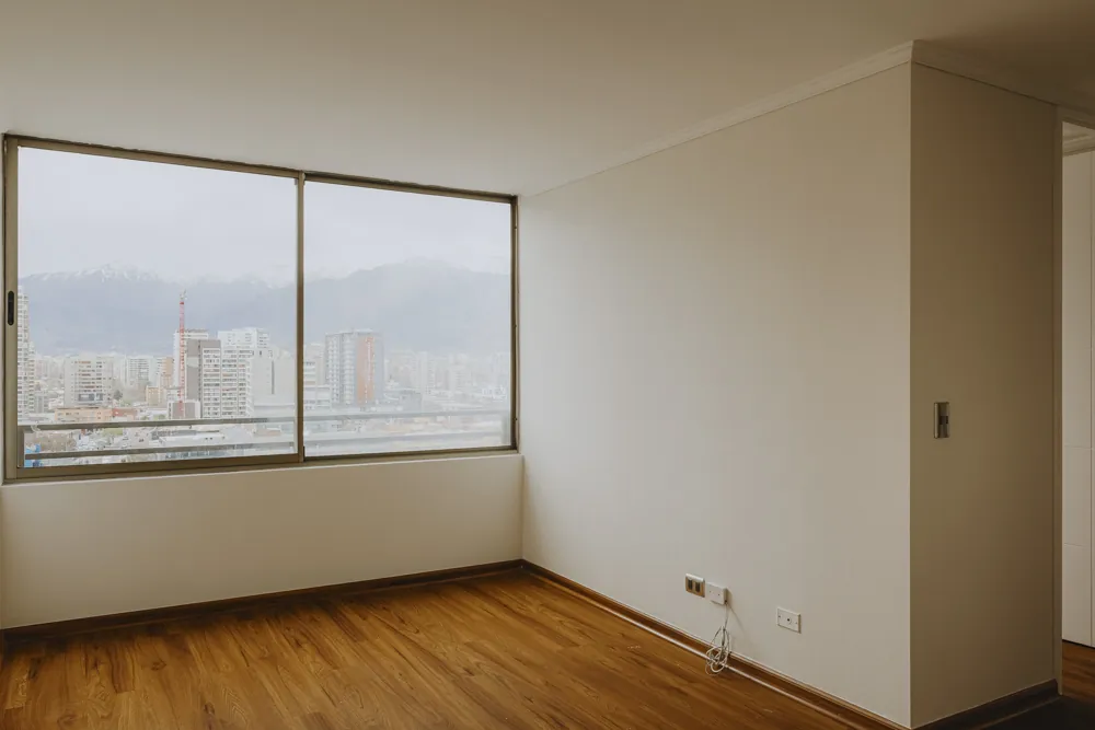 Living con ventana y vista a la cordillera, departamento Av. Vicuña Mackenna 881