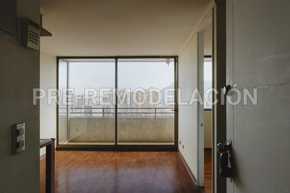 Entrada y living con ventanal, departamento Av. Vicuña Mackenna 881