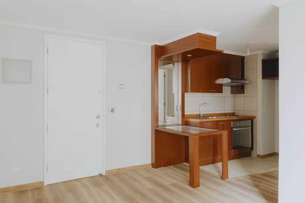 Living, puerta de acceso y cocina, departamento Av. Vicuña Mackenna 881