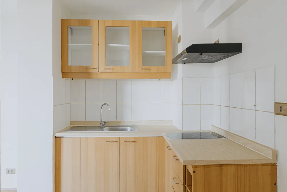 Cocina con muebles de madera y campana, departamento General Mackenna 1138