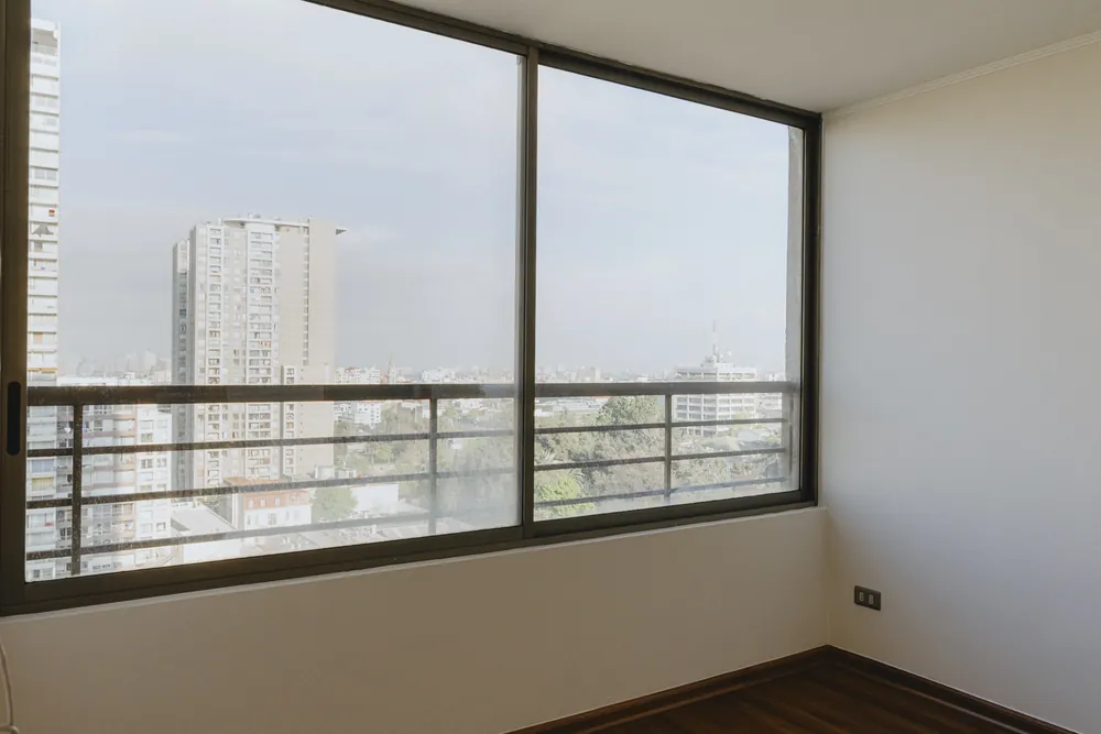 Dormitorio con ventanal y vista a la ciudad, departamento Lord Cochrane 635