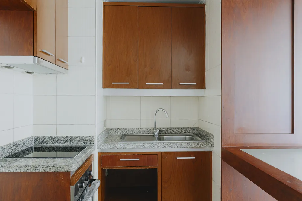 Cocina con muebles de madera y lavaplatos, departamento Morandé 580