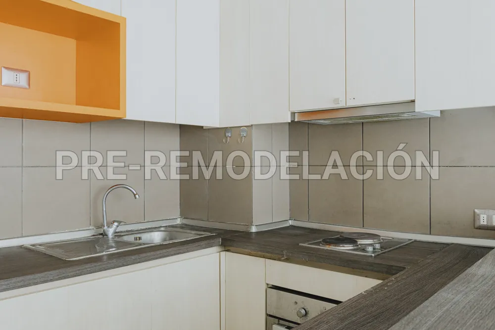 Cocina con cubierta y mueble naranja, departamento Morandé 626