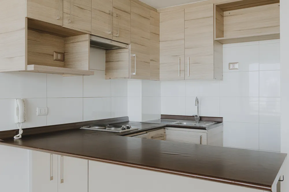 Cocina con encimera y muebles de madera, departamento Recoleta 877