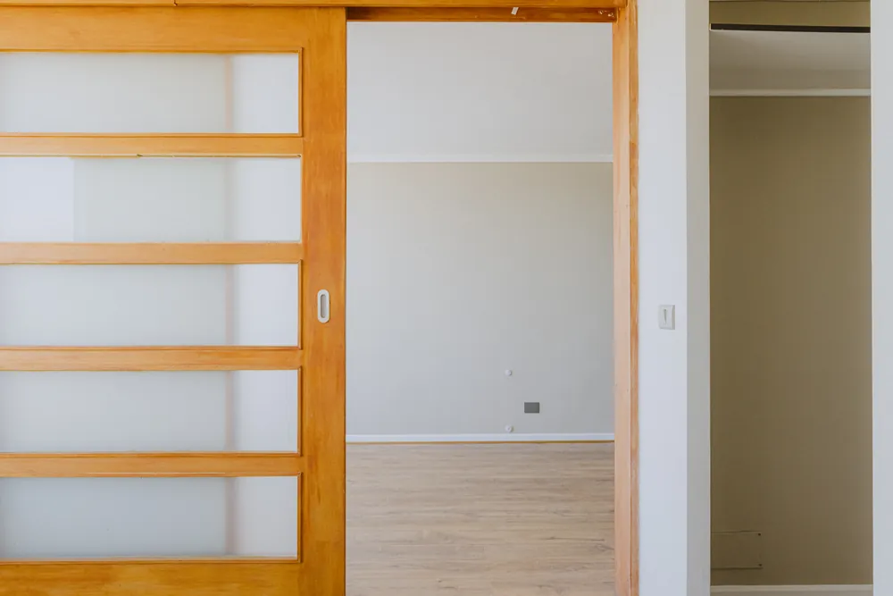 Dormitorio visto a través de la puerta corredera, departamento Santa Rosa 325