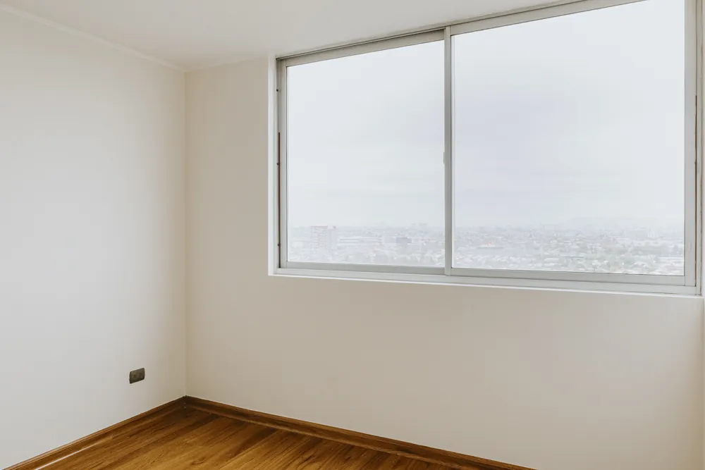 Dormitorio con ventanal y vista a la ciudad, departamento Vicuña Mackenna 2585